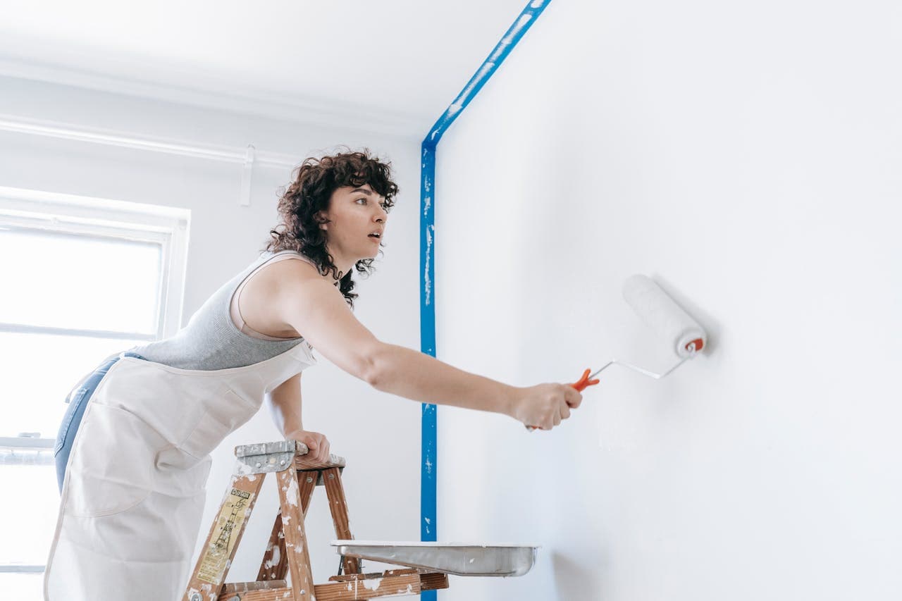 woman painting a white wall